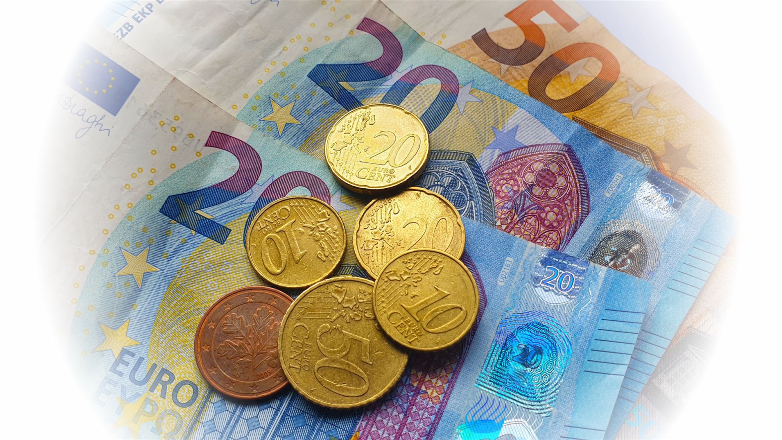 Eine Ansammlung verschiedener Euro-Münzen und Banknoten unterschiedlicher Nennwerte.